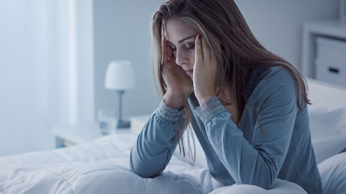 Frau-Bett-erschoepft-168591803-AS-StockPhotoPro