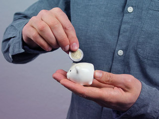 Mann-Geldstueck-Sparschwein-317293217-AS-kittyfly