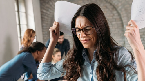Picture of angry overworked businesswoman in office