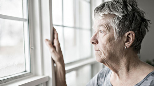 Seniorin-Fenster-einsam-315666800-AS-pololia