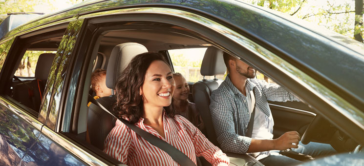 Happy family in car on road trip