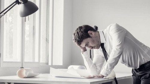 Frustrated business man analyzing plans