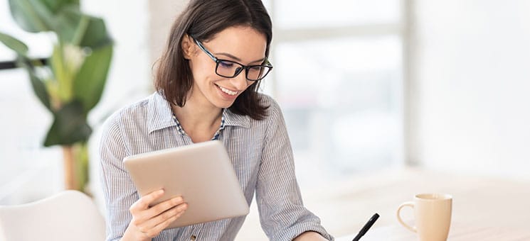 Frau-laechelnd-Tablet-323438238-AS-Prostockstudio
