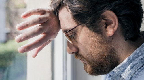 Portrait of one guy longing and looking through window