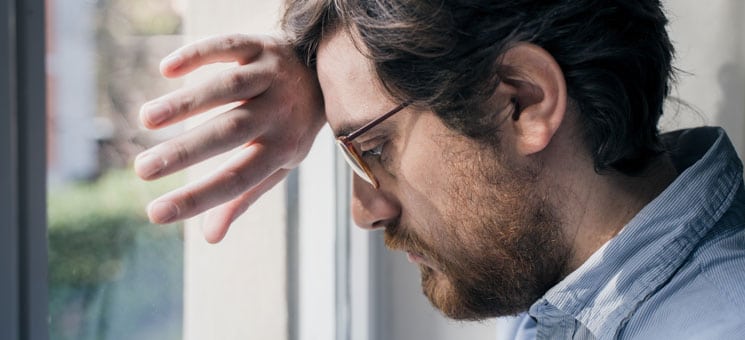 Portrait of one guy longing and looking through window