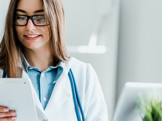 Smiling young female doctor working at the clinic , she is using