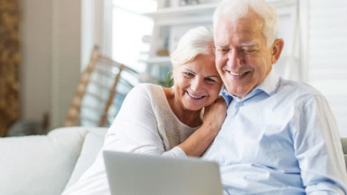 Senior couple using laptop computer at home
