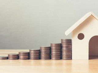 Property investment and house mortgage financial concept, Hand putting money coin stack with wooden house