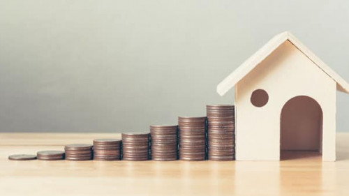 Property investment and house mortgage financial concept, Hand putting money coin stack with wooden house