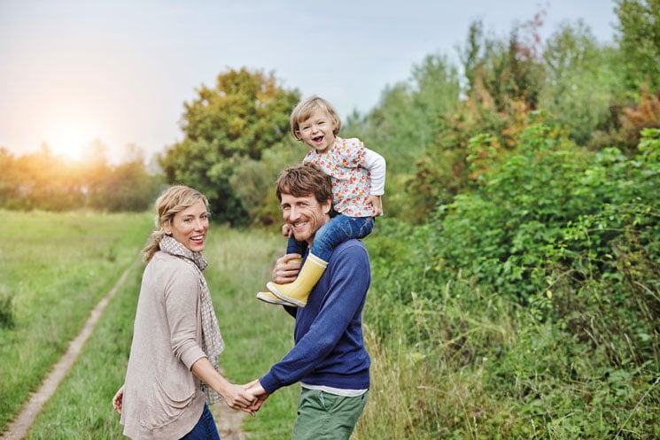 Family on a trip with father carrying daughter on shoulders