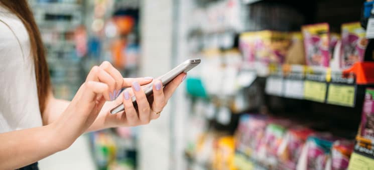 Female customer with phone in hand, food store