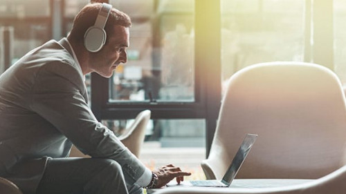 Continue what you've started. Businessman is using laptop in the office. Copy space on the right side