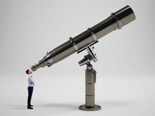 Little businessman looks in binoculars looking to the future concept.