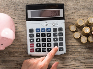 Haende-Taschenrechner-Sparschwein-Muenzen-109276643-AS-Andrey-Popov