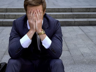Desperate male sitting on ladder near building loosing all money