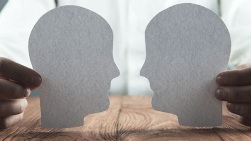 Businessman showing paper human heads on wooden desk. Business c