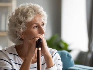 Pensive disabled old lady look in distance mourning