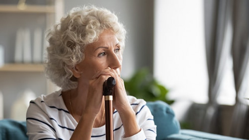 Pensive disabled old lady look in distance mourning