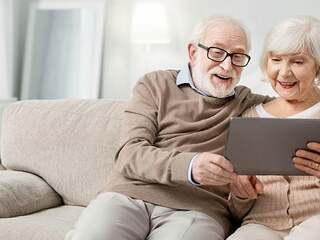 Joyful aged people looking at the tablet screen