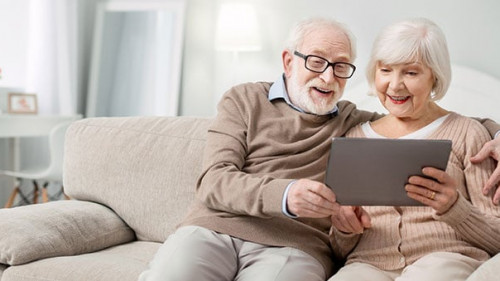 Joyful aged people looking at the tablet screen