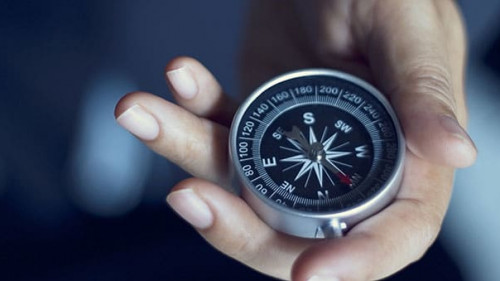 Businessman with a compass holding in hand, color tone film look