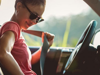 Woman driver buckle up the seat belt before driving car
