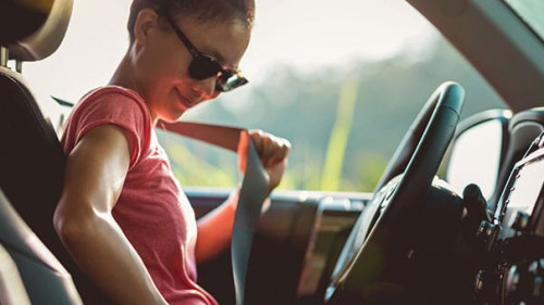 Woman driver buckle up the seat belt before driving car