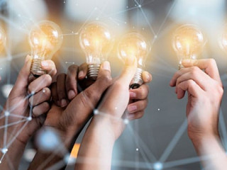 Teamwork and brainstorming concept with businessmen that share an idea with a lamp. Concept of startup