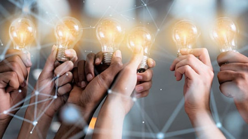 Teamwork and brainstorming concept with businessmen that share an idea with a lamp. Concept of startup