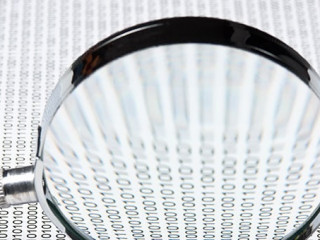 magnifying glass on a binary code
