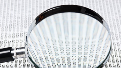 magnifying glass on a binary code