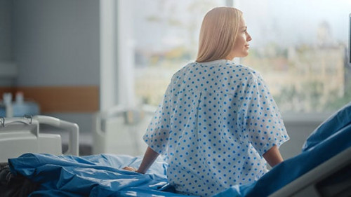 Hospital Ward: Beautiful Caucasian Female Patient Sitting on a B