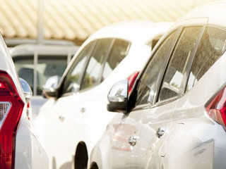 Many white car stop in parking lot outdoor on day.