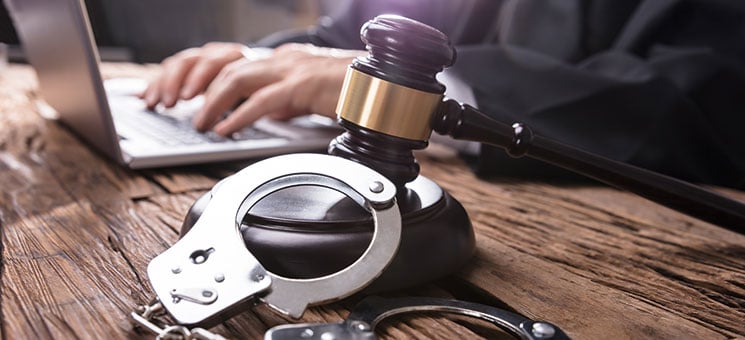 Close-up Of Handcuffs And Gavel In Courtroom