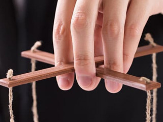 Businessperson Manipulating Marionette