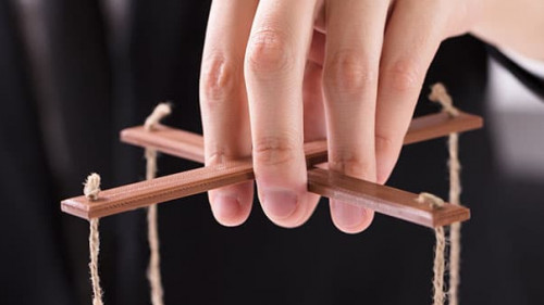 Businessperson Manipulating Marionette