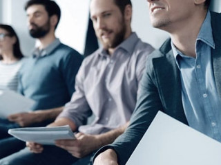 Pleasant man listening to the presentation with his colleagues