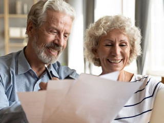 Senior couple use online banking on laptop planning family budget
