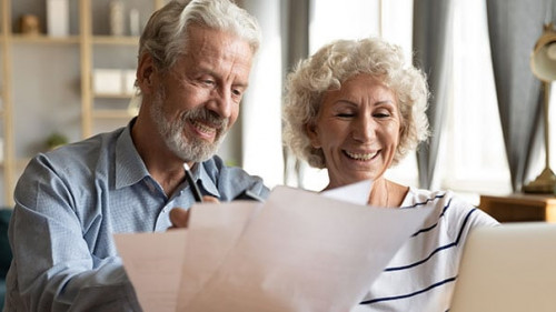 Senior couple use online banking on laptop planning family budget