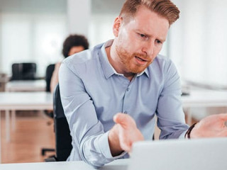 Annoyed business man looking at laptop screen.