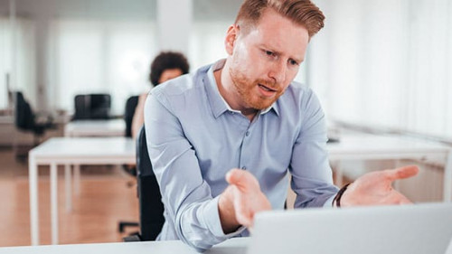 Annoyed business man looking at laptop screen.