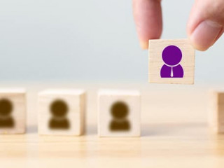 Hand of a businessman chooses a wooden cube block with icon peop