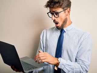 Anzugtraeger-erstaunt-Laptop-343325534-AS-Krakenimages-com