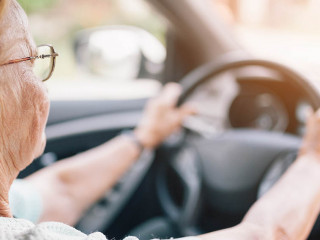 Elderly woman behind the steering wheel of a car