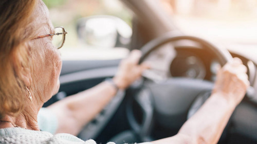 Elderly woman behind the steering wheel of a car