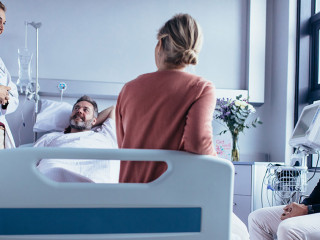 Aerztin-Familie-Krankenbett-178659970-AS-Jacob-Lund