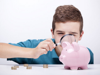 Boy with magnifying glass looking to his savings