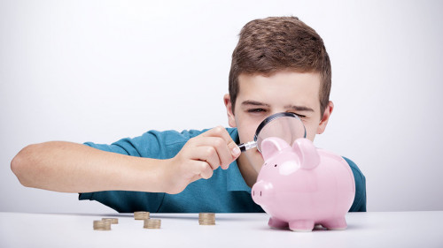 Boy with magnifying glass looking to his savings