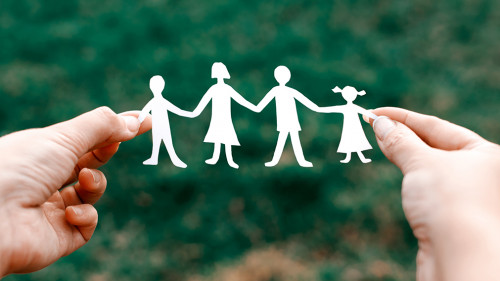 four little men in caring hands