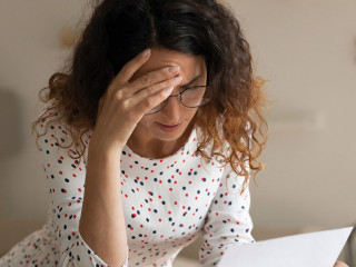 Confused young female open official letter about loan rejection